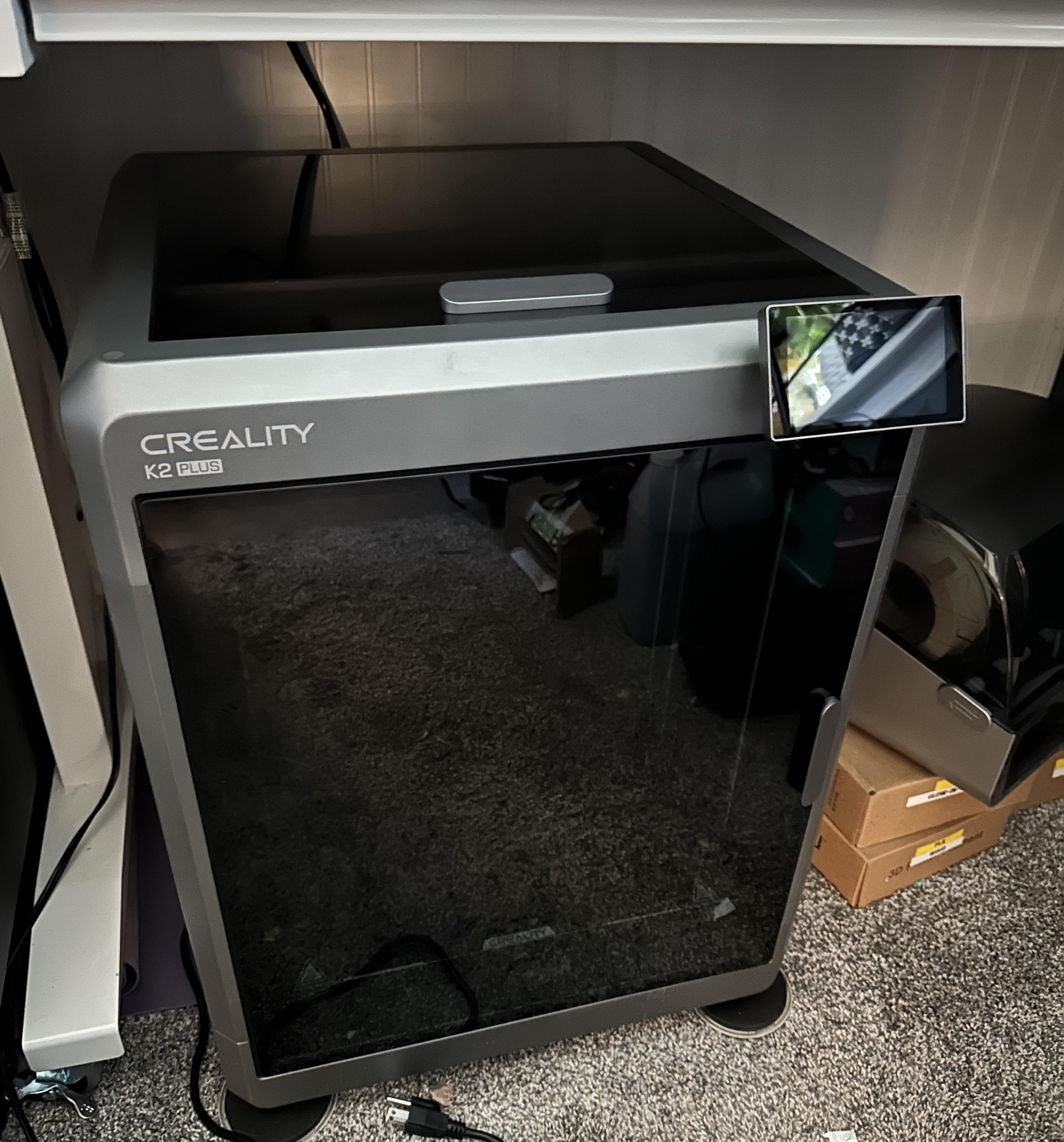 Creality K2 Plus printer on a carpeted floor