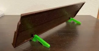 The finished, green 3-D printed kick stand attached to the board