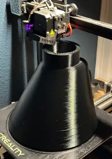 3D printer completing top layers of a black funnel