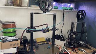 a workbench with two 3d printers