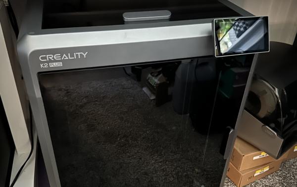 Creality K2 Plus printer on a carpeted floor